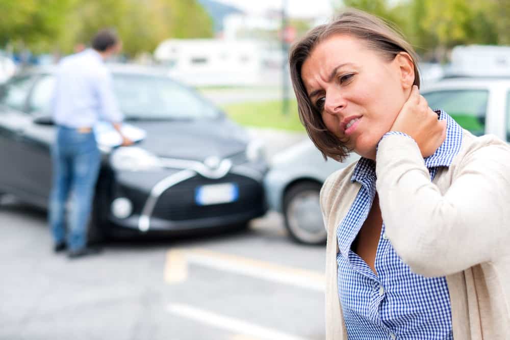 woman holding neck after being injured in a car accident
